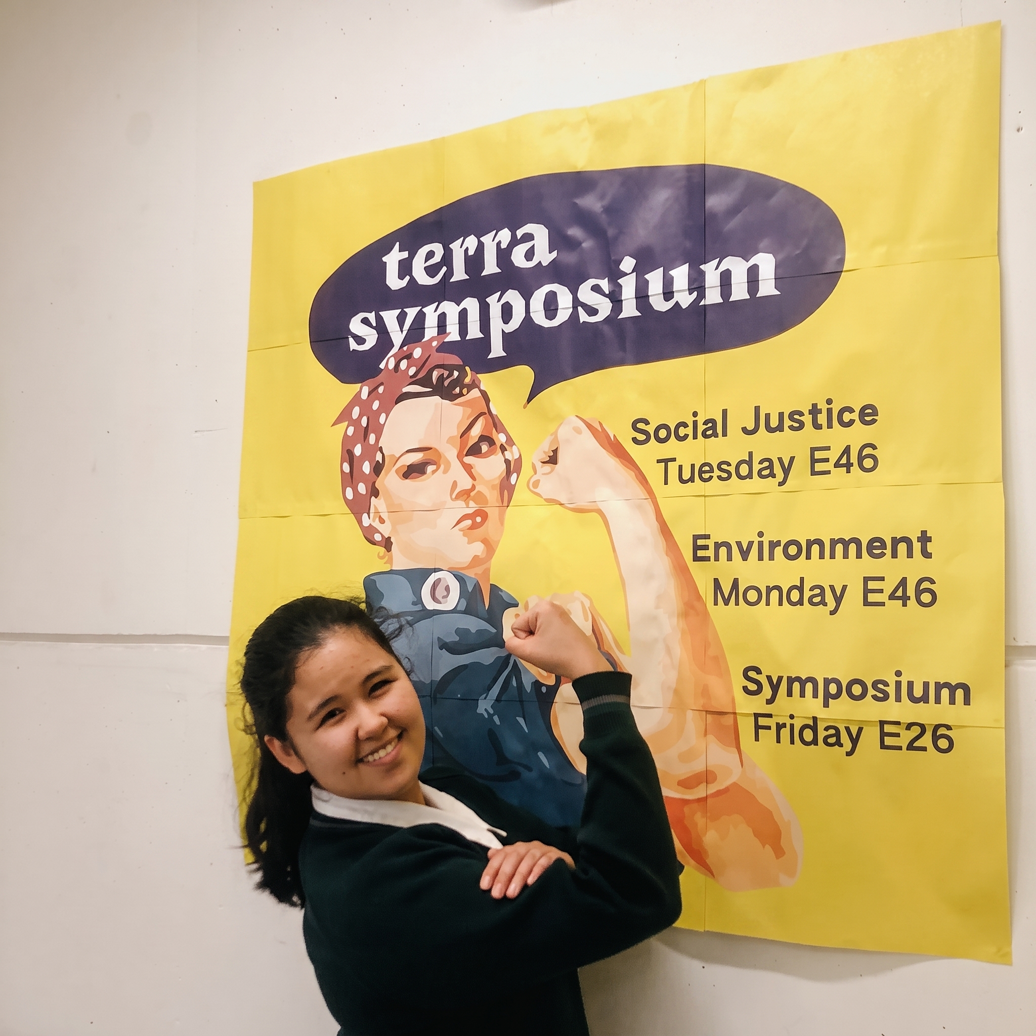 Terra Symposium campaign poster with a student in front of it.